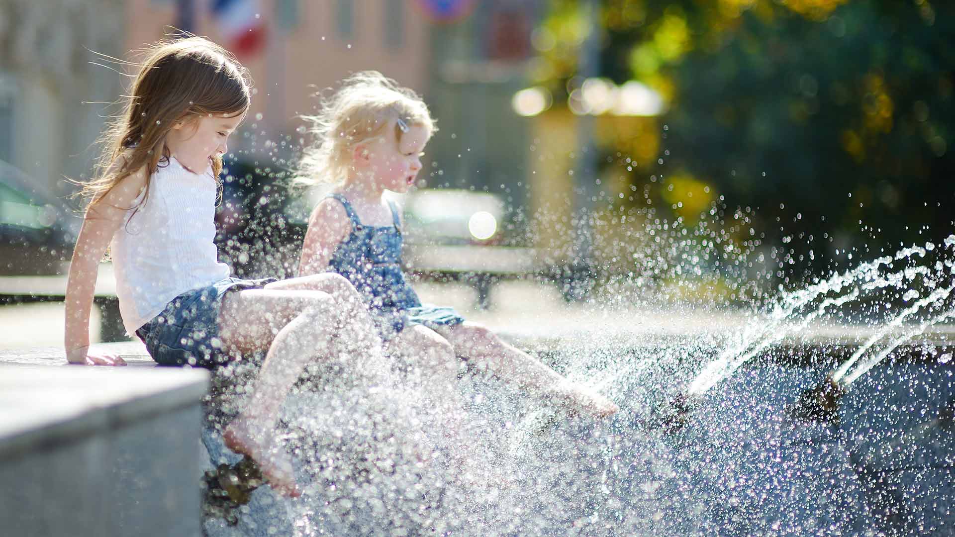 Kinder am Springbrunnen in der Stadt